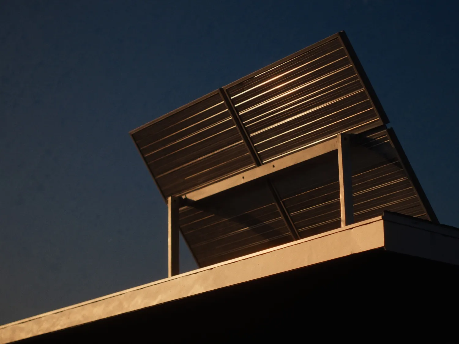 Rooftop solar panels on an Australian home catching warm sunset light
